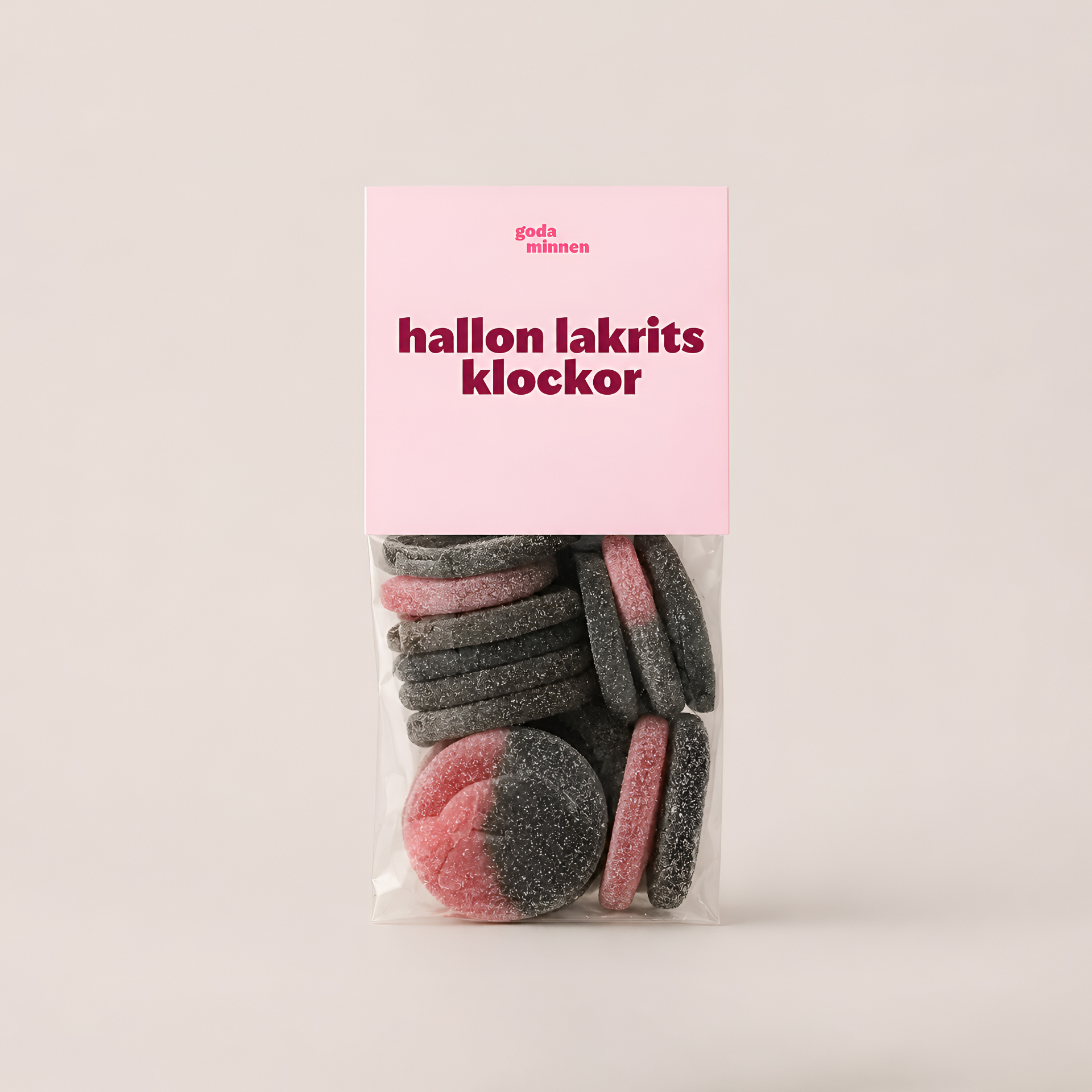 Hallon lakrits klockor — rosa och svarta godisbitar